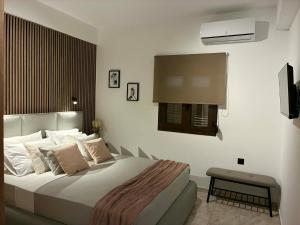 a bedroom with a large bed and a television at Karadinos Apartment in Stílos
