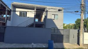 a white house with a fence in front of it at Studio 04 in Aracruz