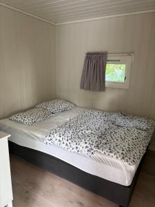 a large bed in a room with a window at Peaceful seaside cabin with guest house - large private outdoor areas and boat available on request in Eigebrekk