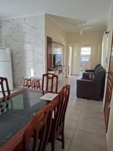 a living room with a glass table and chairs at Apartamento da Adriana in Itajubá