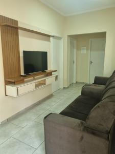 a living room with a couch and a flat screen tv at Apartamento da Adriana in Itajubá