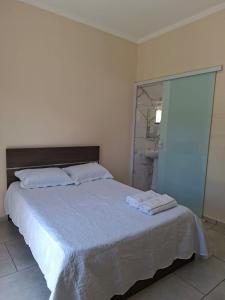 a bedroom with a bed with two towels on it at Apartamento da Adriana in Itajubá +6 photos