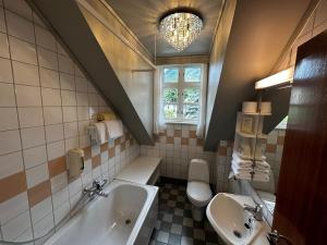a bathroom with a sink and a tub and a toilet at Hofslund Fjord Hotel in Sogndal