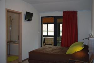 a bedroom with a bed with a yellow pillow and a window at Auberge de Marville in Marville