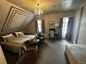 a hotel room with two beds and a chandelier at Hofslund Fjord Hotel in Sogndal