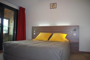 a bedroom with a bed with two yellow pillows at Auberge de Marville in Marville