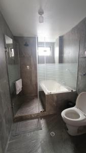 a bathroom with a shower and a toilet and a tub at Refugio Volcán Tungurahua in Ambato
