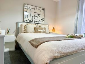 a bedroom with a large bed with white sheets at Ebrington apartment central in Clooney Park