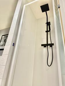 a shower with a shower head hanging on a wall at Ebrington apartment central in Clooney Park
