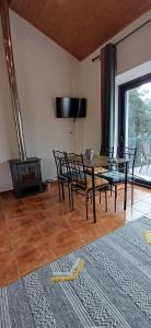 a dining room with a table and chairs and a television at Terras do Salvado Agroturismo in Fundão