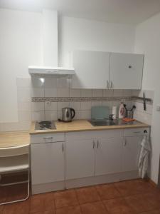 a kitchen with white cabinets and a sink at Komárov Apartment 2 in Komárov