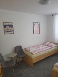a bedroom with a bed and two chairs and a table at Komárov Apartment 2 in Komárov