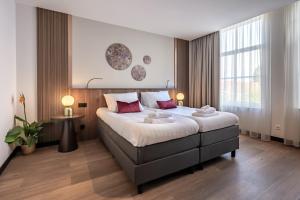 a bedroom with a large bed with red pillows at Zen Kitchen & Boutique Hotel in Brouwershaven