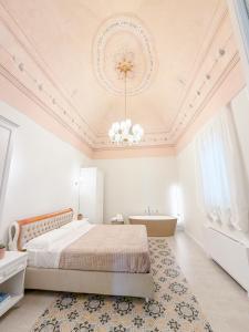 a bedroom with a bed and a bath tub and a chandelier at Palazzo Veneziani - Luxury Living in Monopoli in Monopoli