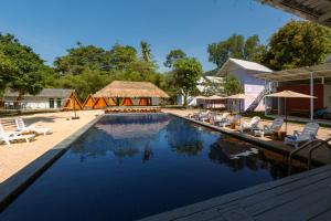 a large swimming pool with chairs and umbrellas at Slumber Resort Koh Chang in Ko Chang
