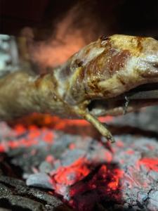 a piece of meat cooking on a grill at Dafinat in Bogovë
