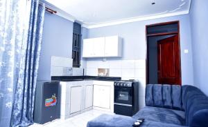 a kitchen with a blue couch in a room at La vue suites in Kampala