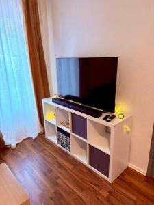 a flat screen tv sitting on a white entertainment center at Le Cosy Home in Guebwiller
