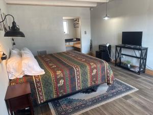 a hotel room with a bed and a television at Tecumseh Inn & Suites in Tecumseh