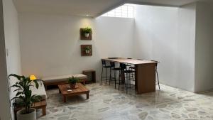 a room with a table and a bench and a bar at Casa Celisa in Cali