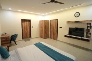 a bedroom with a bed and a flat screen tv at Corbett Valley View in Tota Ām