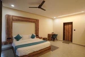 a bedroom with a bed with a ceiling fan and a desk at Corbett Valley View in Tota Ām