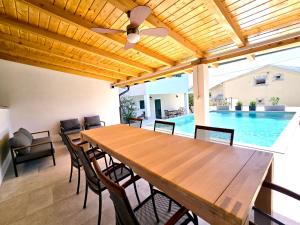 a dining room with a table and a swimming pool at Mare`s Private House 1st floor with Pool in Karlobag
