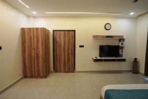 a room with two wooden doors and a tv at Corbett Valley View in Tota Ām +30 photos