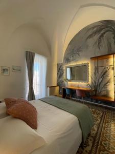a hotel room with a bed and a mirror at Palazzo Flora in Collepasso