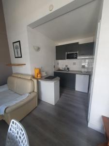 a living room with a couch and a kitchen at résidence lac de La Sole T3 4 pers les minimes avec piscine in La Rochelle +7 photos