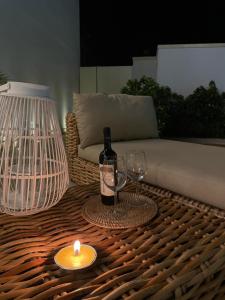 a candle and a bottle of wine and glasses on a table at Palazzo Flora in Collepasso