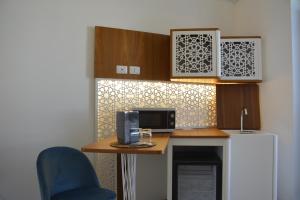 a kitchen with a counter with a microwave and a refrigerator at Palazzo Flora in Collepasso +25 photos