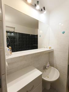 a white bathroom with a sink and a mirror at Garzónka Trenčín in Trenčín