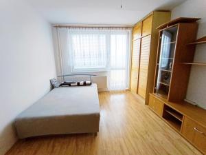 a bedroom with a bed and a large window at Garzónka Trenčín in Trenčín
