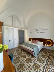 a bedroom with a bed and a wall with a quote at Palazzo Flora in Collepasso