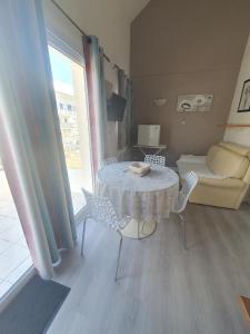 a living room with a table and chairs and a couch at résidence lac de La Sole T3 4 pers les minimes avec piscine in La Rochelle