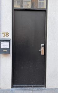 a black door with a sign in front of it at Hotel Bellington in Amsterdam