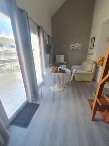 a living room with a table and a couch at résidence lac de La Sole T3 4 pers les minimes avec piscine in La Rochelle