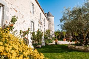 a garden with statues in front of a building at Manoir La Ville Durand in Binic
