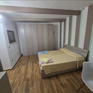 a bedroom with a bed and a wooden floor at La Nicchia Del Borgo in Badolato