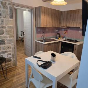 a kitchen with a white table and a sink at La Nicchia Del Borgo in Badolato