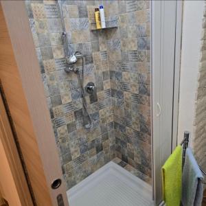 a bathroom with a shower with a glass door at La Nicchia Del Borgo in Badolato