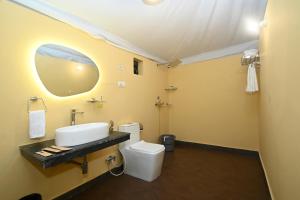 a bathroom with a white toilet and a sink at Baghin Resort in Khilchipur