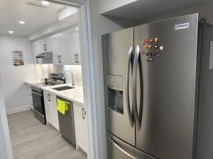 a kitchen with a stainless steel refrigerator at New and Stylish 3BR Private Basement Apartment with 3 Baths & Parking in Richmond Hill