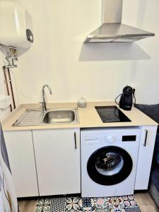a kitchen with a sink and a washing machine at Acogedor apartamento de 2 habitaciones, parking & conford in El Astillero