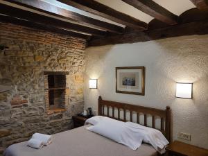 a bedroom with a bed and a stone wall at Hotel Convento San Roque in Balmaseda +27 photos