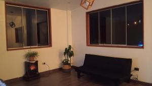 a living room with a couch and two windows at Casa Blanca Andina in Cajamarca +6 photos
