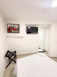 a white room with a bed and a tv at Mosaico Cartagena Hotel in Cartagena de Indias +54 photos