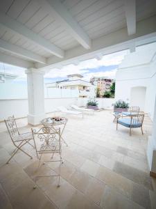 a patio with chairs and a table on a roof at Palazzo Veneziani - Luxury Living in Monopoli in Monopoli
