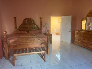 a bedroom with a large wooden bed and a dresser at Montego Bay Sea View Guesthouse in Montego Bay